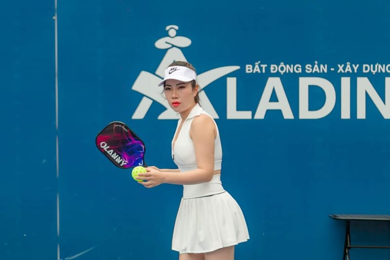 Light coloured pickleball paddle with a ball