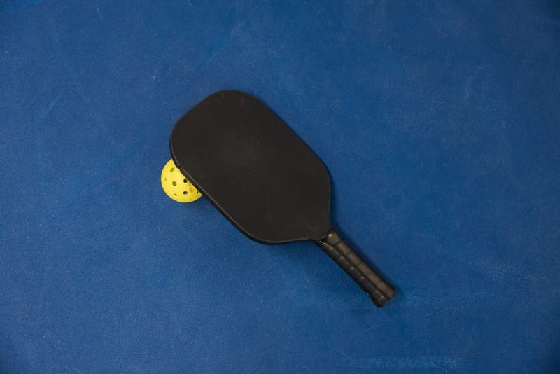 A pickleball paddle on a plain blue background
